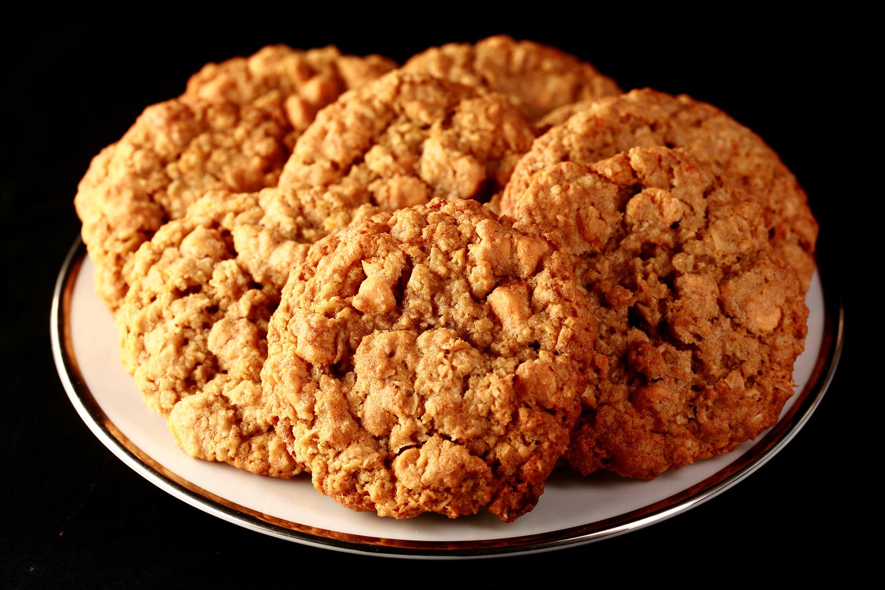 Close up photo of a plate of gluten-free oatmeal cookies with visible butterscotch chips