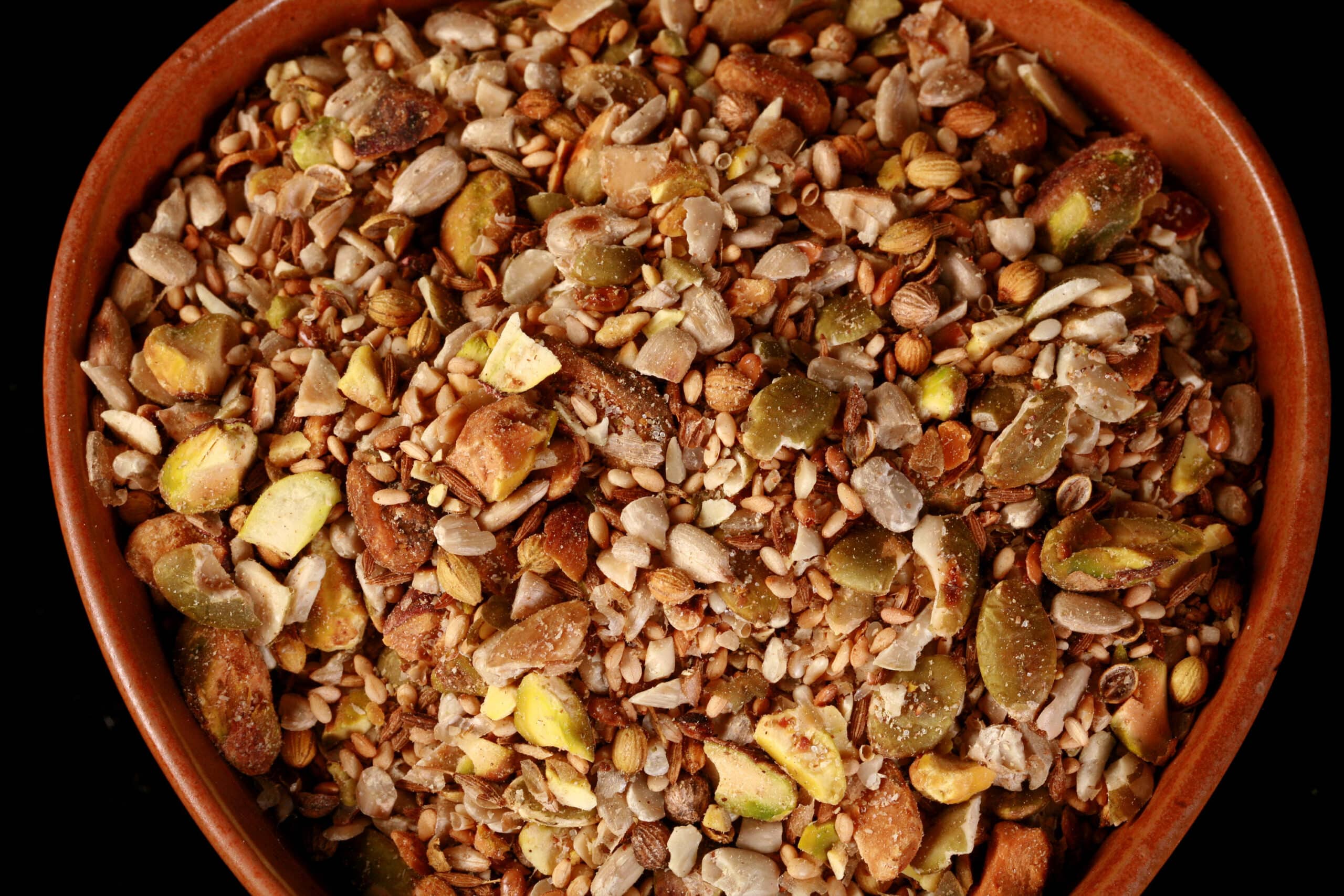 A small brown bowl of pistachio dukkag spice mix.