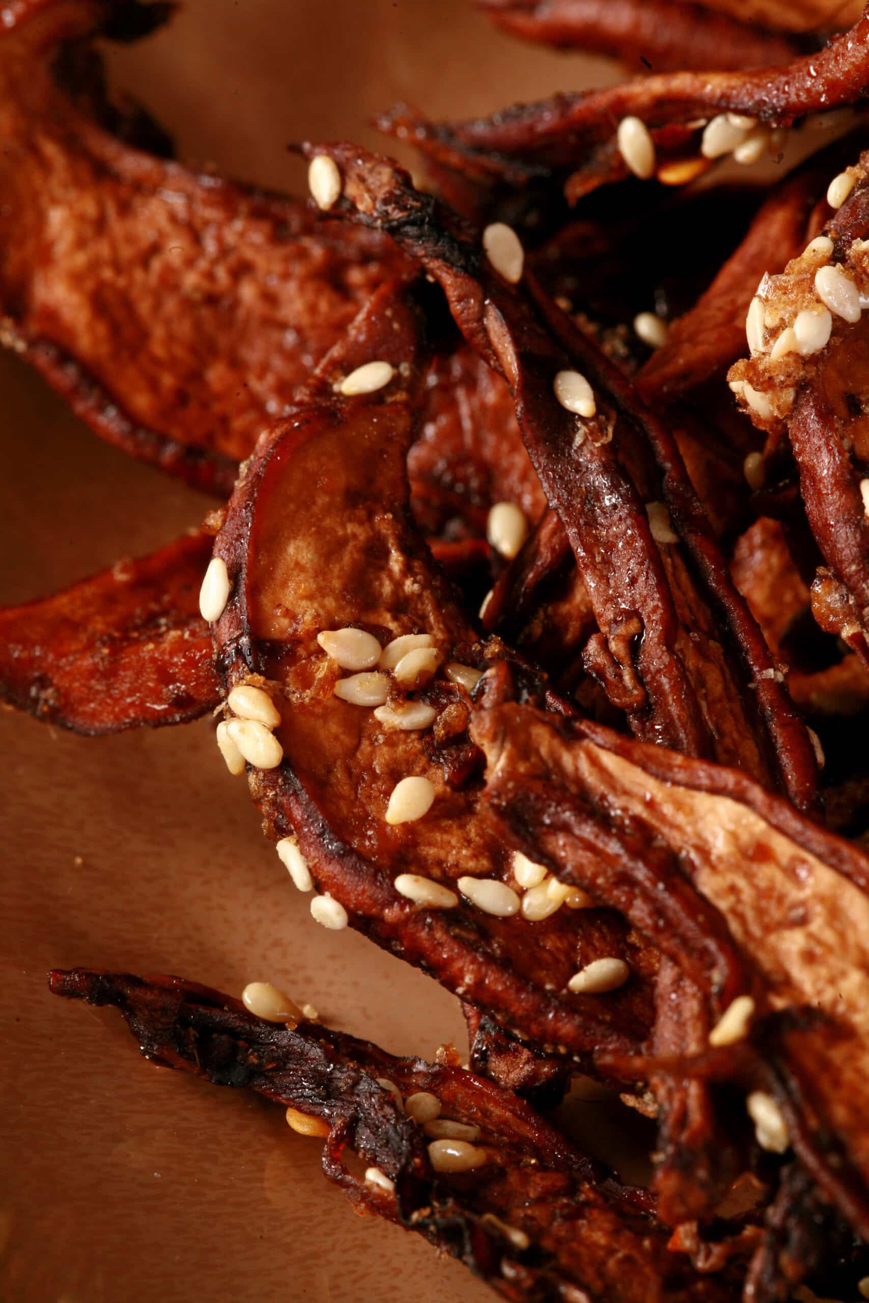 A plate of homemade mushroom jerky made from portabello mushroom slices. This batch has sesame seeds visible.