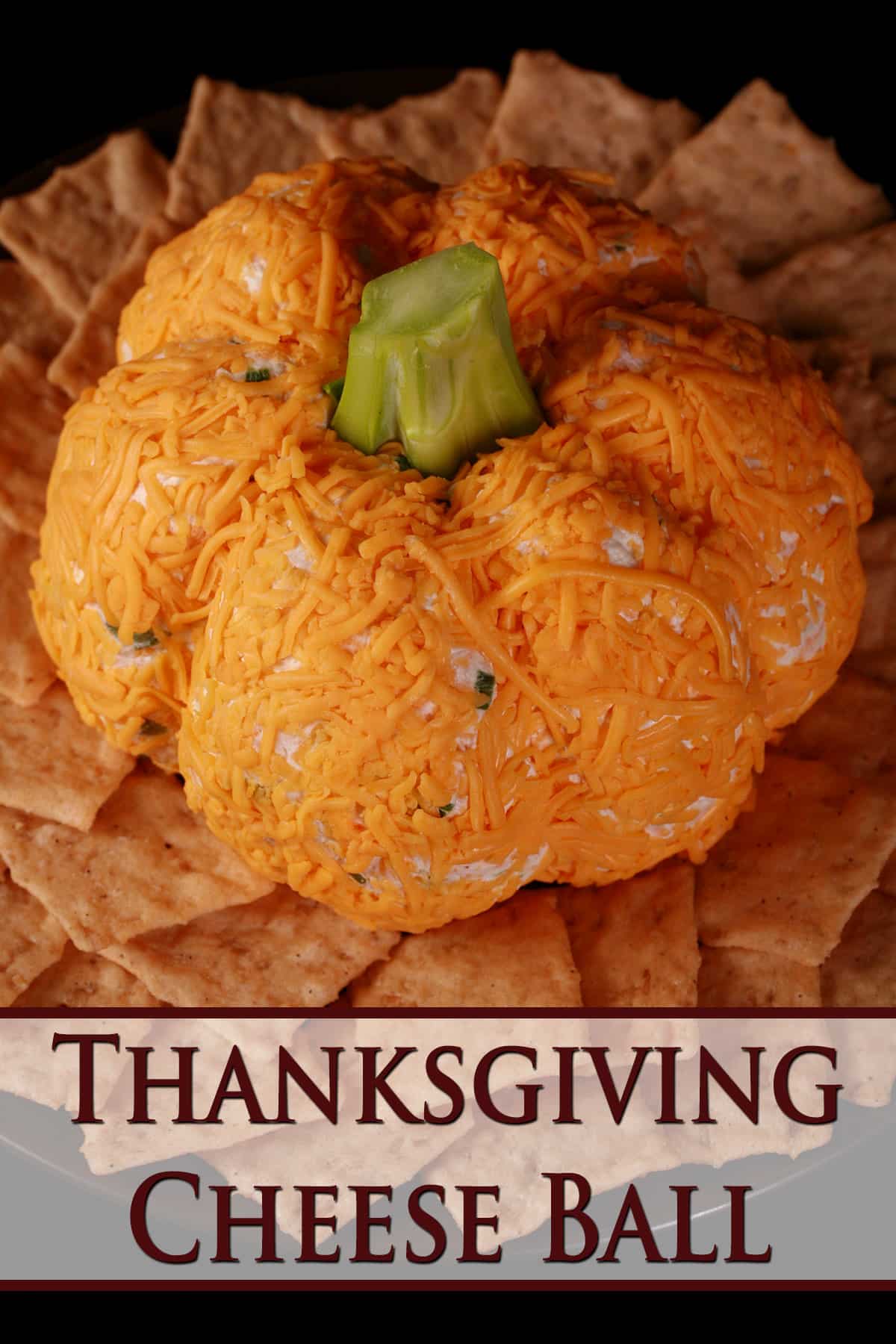 A Thanksgiving cheese ball on a plate with crackers.