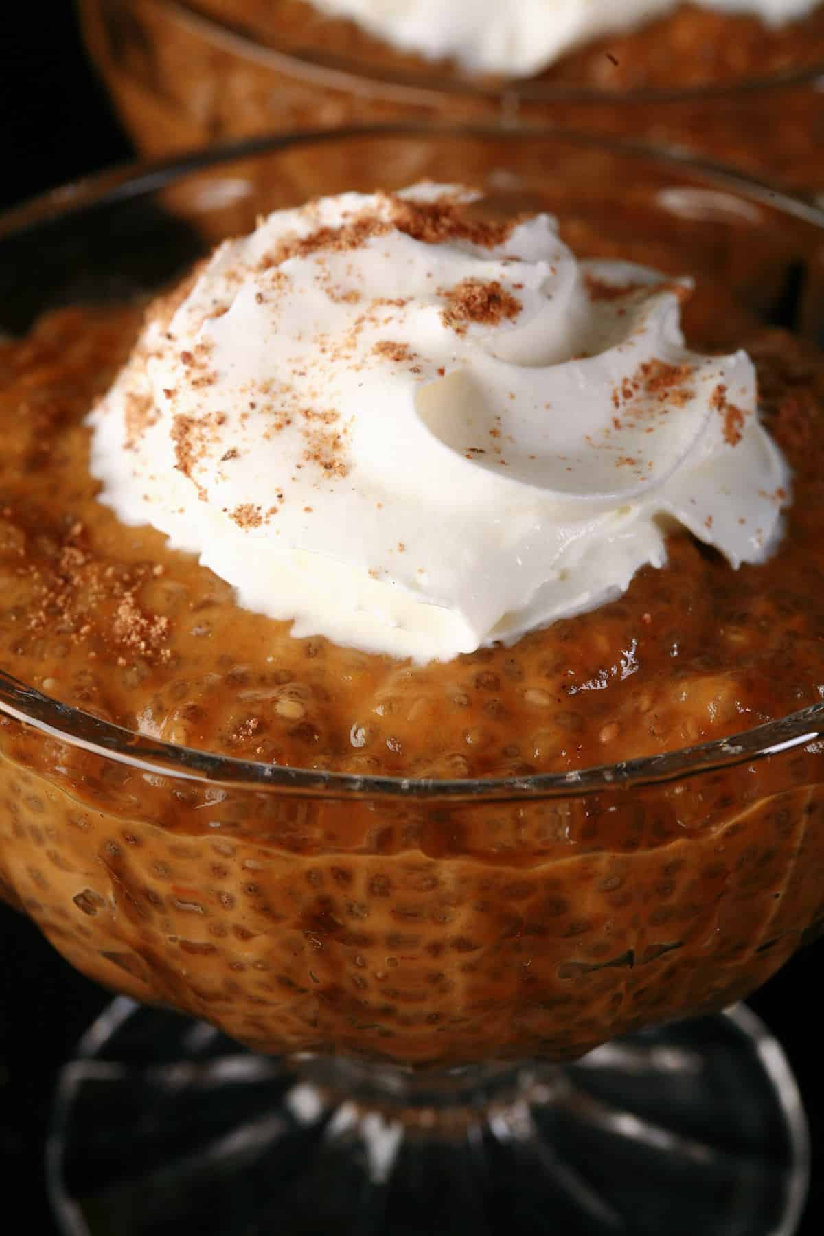 Pumpkin Chia Pudding in a glass cup, topped with whipped cream and nutmeg.