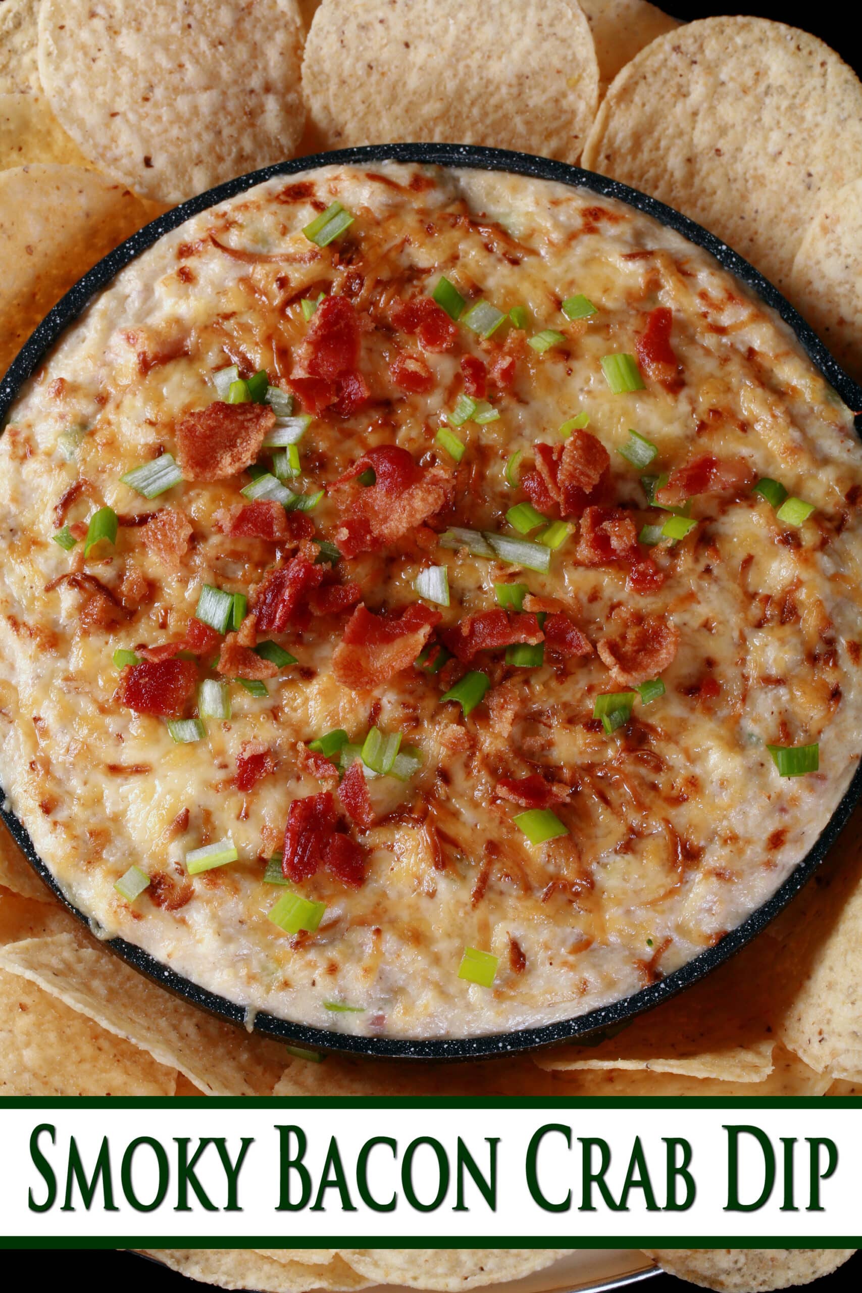 A cast iron pan of smoky hot bacon crab dip, surrounded by tortilla chips.