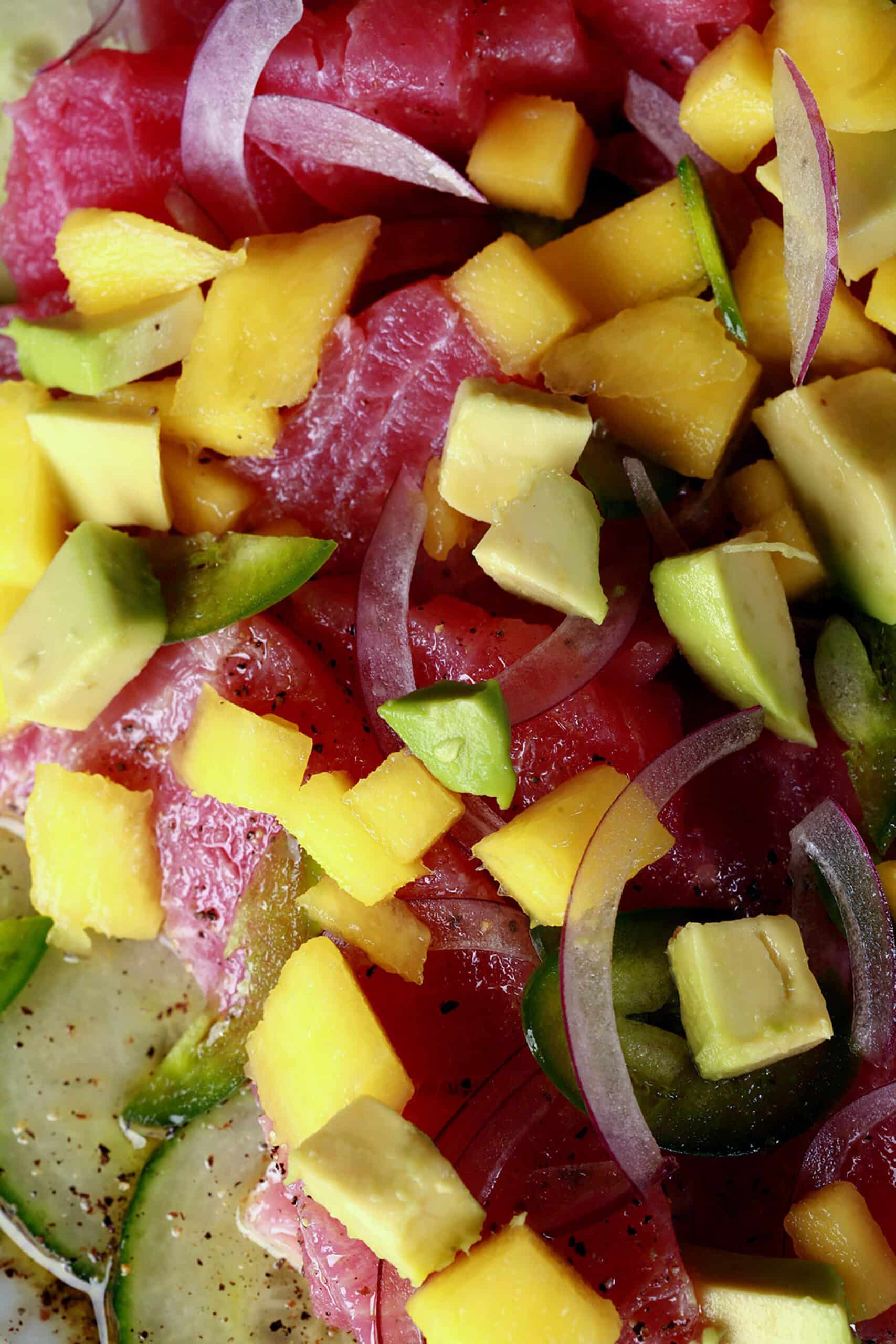 A close up photo of ahi tuna crudo, with mango, avocado, jalapenos, and a citrus vinaigrette.