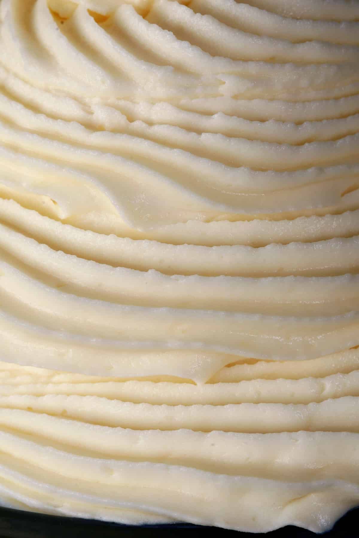 A tall swirl of whipped white chocolate ganache in a small bowl.
