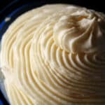 A tall swirl of whipped whiite chocolate ganache in a small bowl.